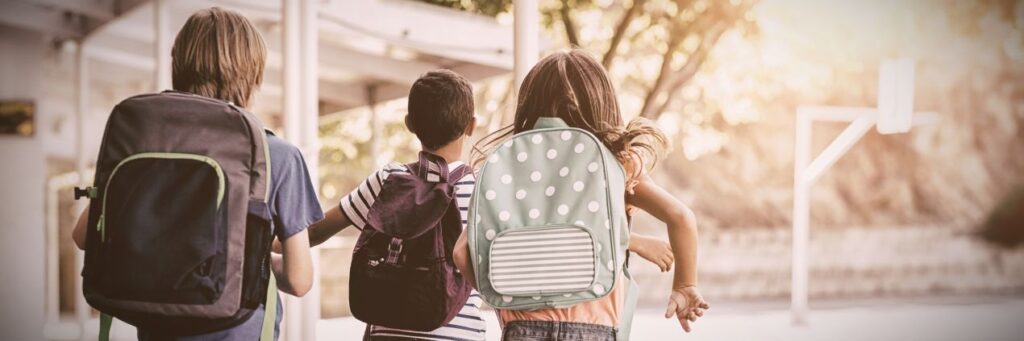 Drei Kinder mit Schulranzen laufen zur Schule – Symbolbild fuer Elternentscheidung und kosten privatschule berlin