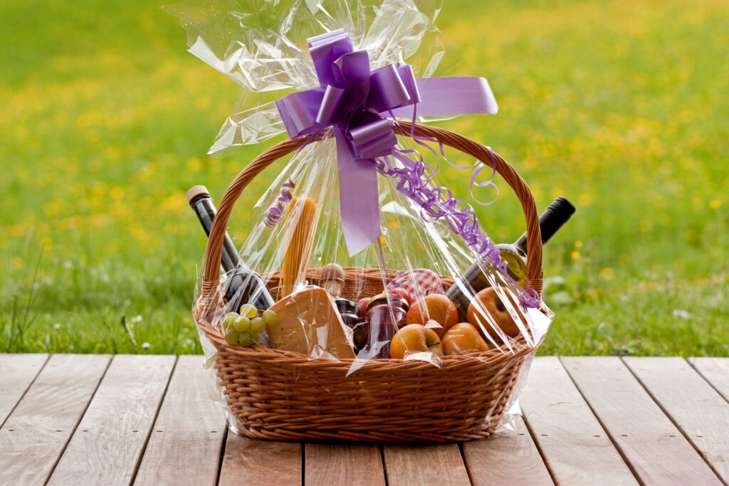 Geschenkkorb mit Wein, Obst und Spezialitäten auf Holzboden
